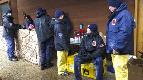 National Urban Search & Rescue Response System Orange County CATF-5 team members Imelda Cordova, third from right, talks Andrew Ricker, and Craig Stevens, far right, as their team take cover from the rain in Paradise, Calif., Friday, Nov. 23, 2018.