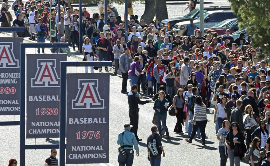 People line up to get in to a memorial service for the victims of Saturday's  shootings. The service was held at the University of Arizona campus in Tucson on Wednesday.