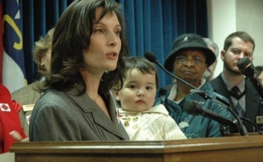 Sato holds Hana as she speaks during a 2009 press conference at the North Carolina state Legislature about the need for paid sick days.