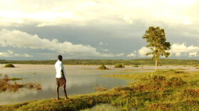 Jackson Omondi observing the floodwater from the edge of his property in the Nyanza Province of western Kenya. Dominion Farms, an American company, is flooding his home as part of a massive development project in the region.