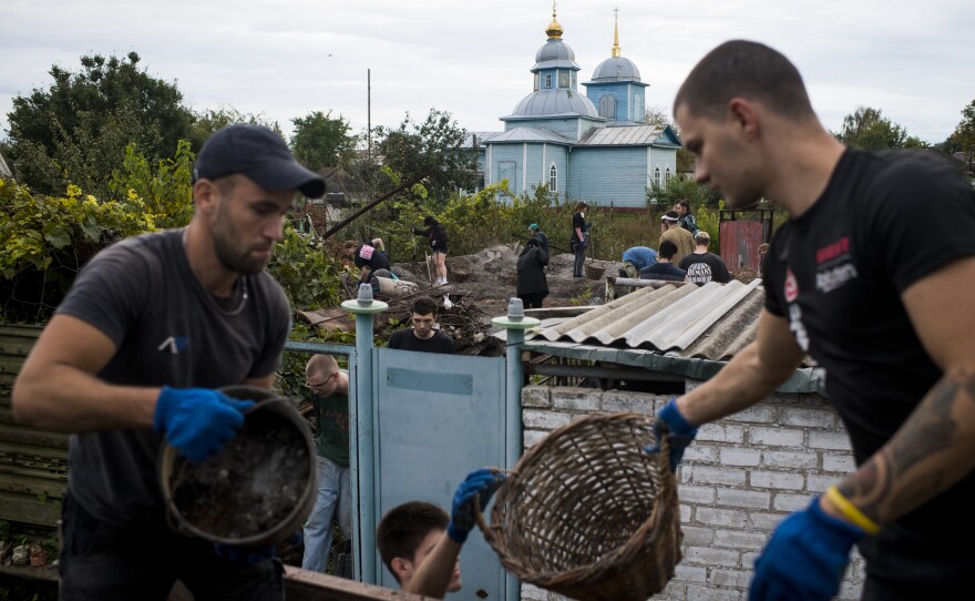 Repair Together volunteers work to clean up the destroyed home of Kateryna Yurchenko in Kolychivka.