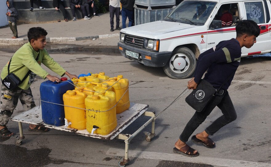 Internally displaced Palestinian children use a makeshift wheeled cart to haul water in Rafah in the southern Gaza Strip on Sunday, as battles continue between Israel and the militant group Hamas.
