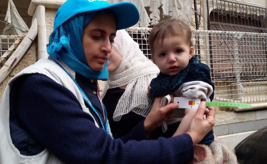 Dr. Rajia Sharhan, UNICEF Nutrition Specialist, takes a child's mid-upper arm circumference in Madaya, Syria, on Thursday. The city was under siege by government forces and didn't receive aid for months. Dozens of people have died of malnutrition.