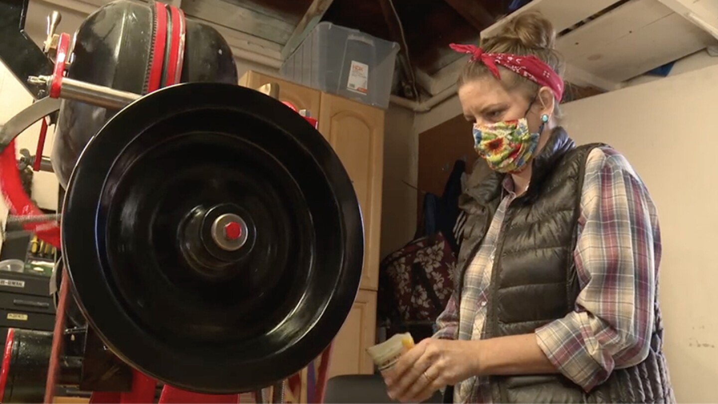 Brijette Peña, owner of San Diego Seed Company, works with a seed packing machine.