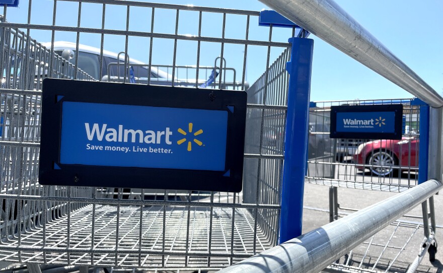 Shopping carts sit in the parking lot of a Walmart store in Rohnert Park, Calif., on Aug. 4. In a letter to shareholders, Walmart's CEO said its customers are spending less on clothing and other merchandise because food prices have continued to rise.