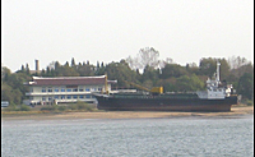 Across the Yalu River, a beached ship sits in front of a North Korean luxury hotel.