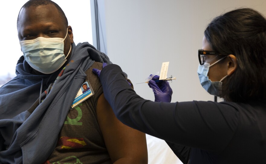 Dr. Stephaun Wallace, who leads the global external relations strategies for the COVID-19 Prevention Network at the Fred Hutchinson Cancer Research Center in Seattle, receives his second injection from Dr. Tia Babu during the Novavax vaccine phase 3 clinical trial in February 2021.