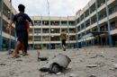 Palestinian children walk past debris in the courtyard of a school run by the United Nations Relief and Works Agency for Palestine refugees following Israeli airstrikes targeting Gaza City on Monday.