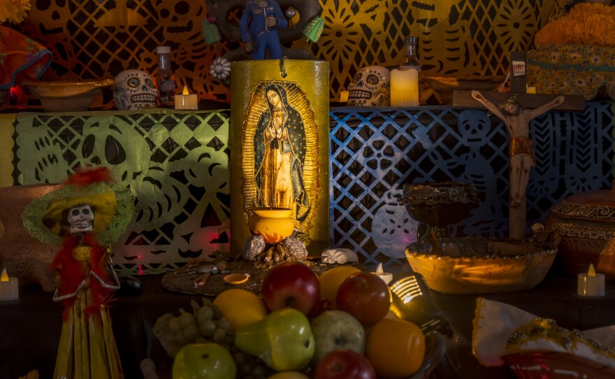 A religious candle with the Mexican Saint the Virgin of Guadalupe is burning as part of the Día de Muertos altars at the Sherman Heights Community Center, Oct. 15, 2024.