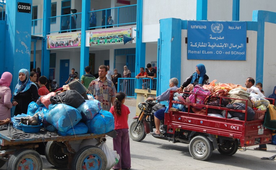 Palestinian families arrive at al-Remal Elementary School, which is run by the U.N. Relief and Works Agency, or UNRWA. The director of UNRWA operations in Gaza says the U.N. expects 50,000 evacuees to seek shelter at schools like this one.