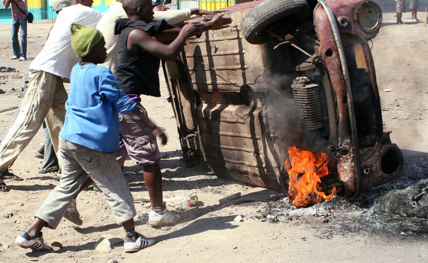 Last September, Mozambican protesters overturned a burning car in Maputo. Police patrolled the streets of the tense capital after President Armando Guebuza called for calm following protests over food and fuel prices.
