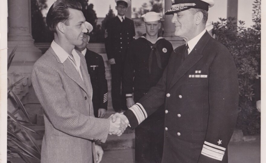 Maurice Young, 26, is congratulated by Rear Adm. R. S. Holmes upon being the 3,000th man to enlist in the Navy in San Diego after the attack on Pearl Harbor.