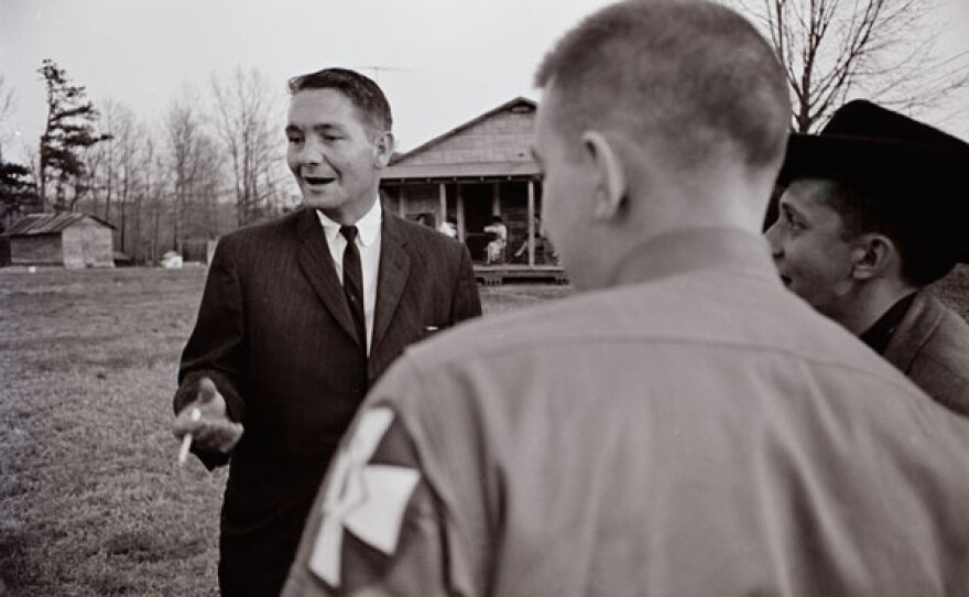 Bob Jones, smoking and wearing a suit, speaks to KKK members, April 1964.