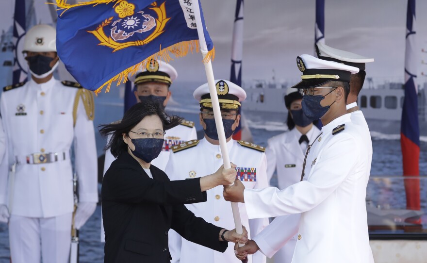 Taiwan's President Tsai Ing-wen (left) presents a flag during the commissioning ceremony of the a domestically made warship at the Suao Naval Base in Yilan county, Taiwan, on Sept. 9. Taiwan's president oversaw the commissioning of the new ship as part of the island's plan to boost its defense capacity amid heightened tensions with China.