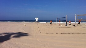 A few volleyball players are about the only people at Mission Beach after a second shark sighting in two days prompts lifeguards to keep swimmers out of the water. 