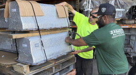 Chris McQuiggen and Archie Brewton of Everett Auto Parts strap two Chevy Volt batteries to a pallet in preparation for shipping. The batteries are separated by a layer of wood so they don't make contact with each other. Everett Auto Parts found a battery recycler who will accept these hybrid vehicle batteries, but the salvage yard won't make any money off of them.