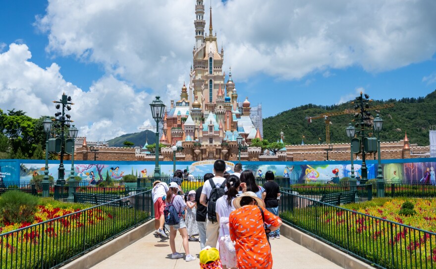 Visitors take photos at the Disneyland Resort in Hong Kong on June 18, 2020.