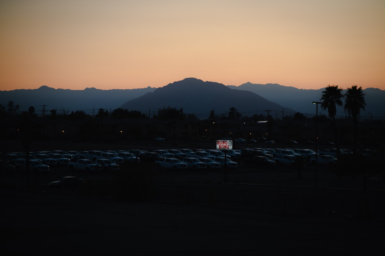 Sunset illuminates the sign outside Imperial County Farm Bureau and cars drive down the street in El Centro, California on February 13, 2024.