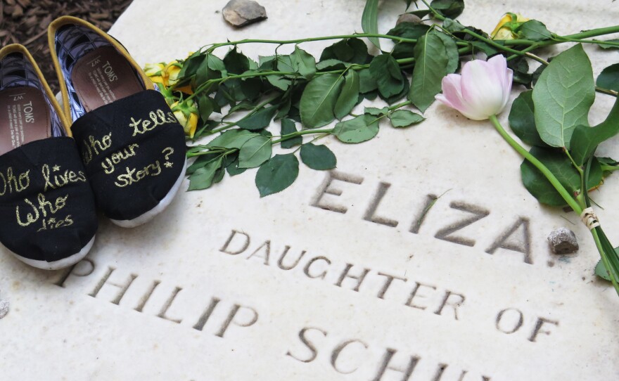 Visitor Stacy Kmentt photographed her shoes, which she decorated with a lyric from the musical, on top of Eliza Hamilton's gravestone in New York City.