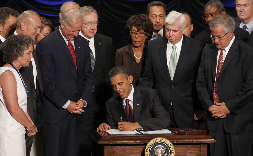 President Obama signs the Dodd-Frank financial overhaul bill in Washington on July 21, 2010. Five years later, debate over the effectiveness of the legislation continues.