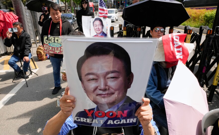 A supporter of former South Korean President Yoon Suk Yeol holds up his portrait during a rally outside of the Seoul High Court in Seoul, South Korea, Wednesday, April 29, 2026.