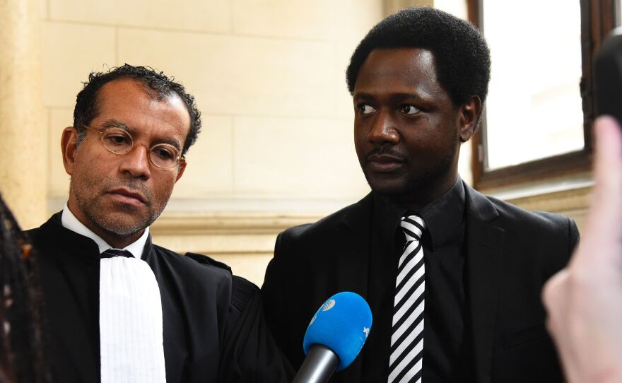 Souleymane Sylla (right) with his lawyer in Paris on Tuesday during the trial of the four British men accused of racist violence towards him in February 2015.