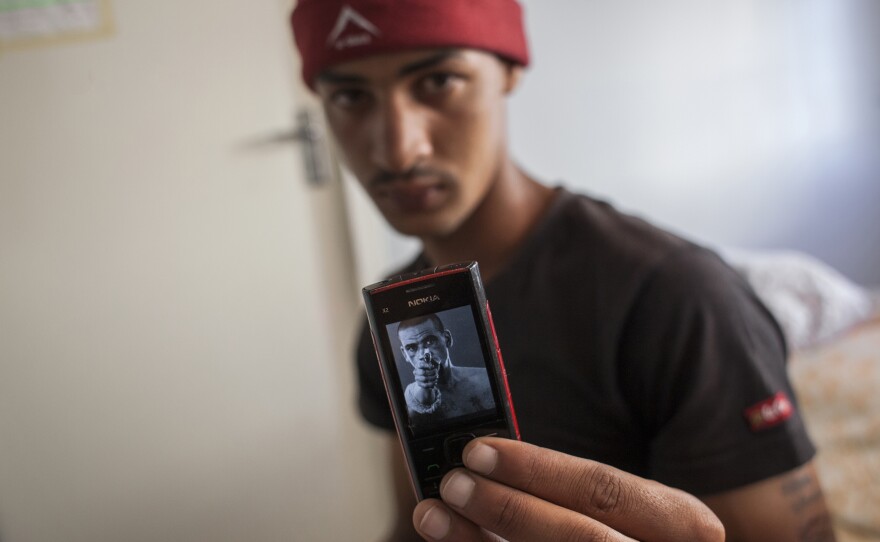 Ashwin showing a picture of actor Brendon Daniels on his phone. Daniels plays a reformed gangster in <em>Four Corners</em>, a coming-of-age crime drama set in Cape Town. 2014.