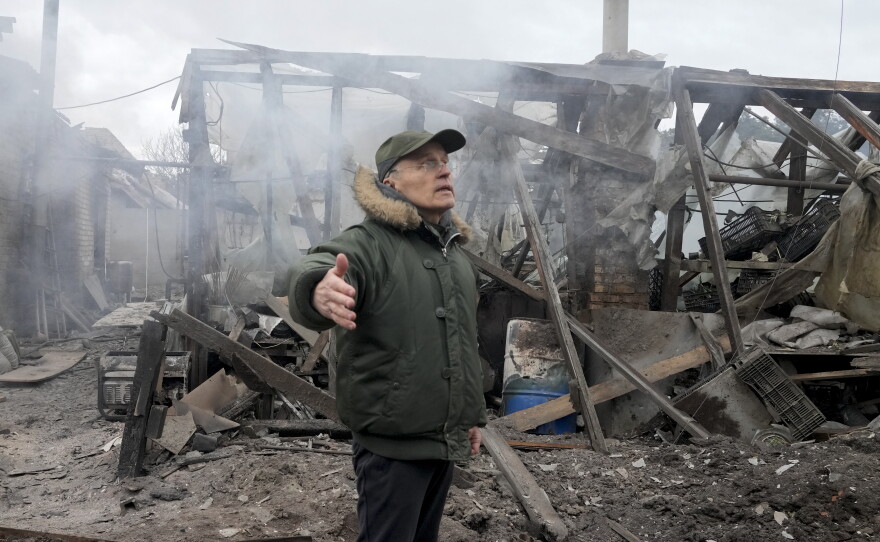 A man stands near a house destroyed in Russian artillery shelling in the Kyiv suburb of Horenka on March 6, 2022.