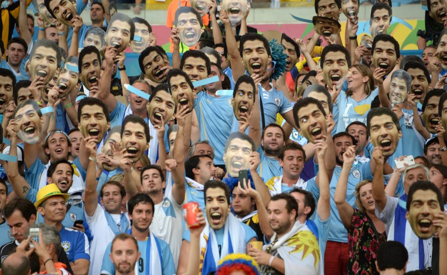 Uruguay's fans hold up cut-out images of forward Luis Suarez in Rio last month. The striker's World Cup ended in embarrassment, but he'll have a chance to start over in Barcelona.