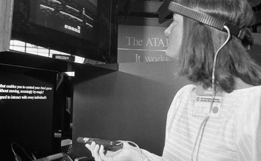 The "Atari Dump" of New Mexico, where the game company rid itself of unsold game cartridges, will be excavated this summer. Here, a file photo shows a woman demonstrating Atari's unreleased 1984 Mindlink device, using a headband that picks up impulses from movement of the player's forehead.