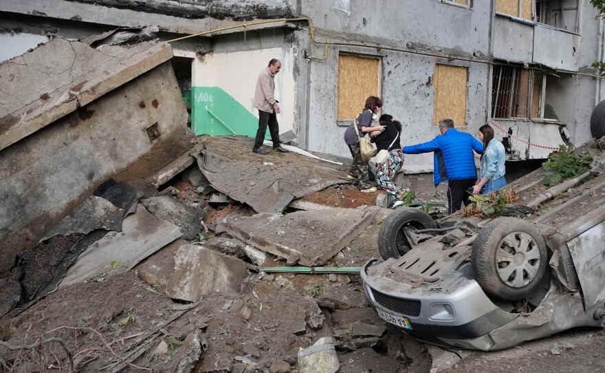 Local residents walk amid debris following a Russian missile attack in Kyiv, Ukraine, Monday, July 6, 2026.