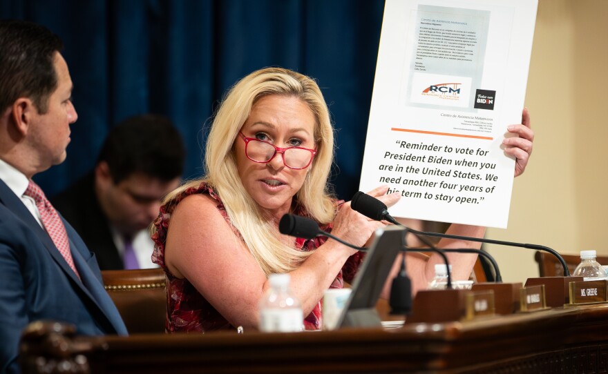 Rep. Marjorie Taylor Greene, R-Ga., holds a sign showing a screenshot of the viral flyer as Secretary of Homeland Security Alejandro Mayorkas testifies before the House Homeland Security Committee on April 16.