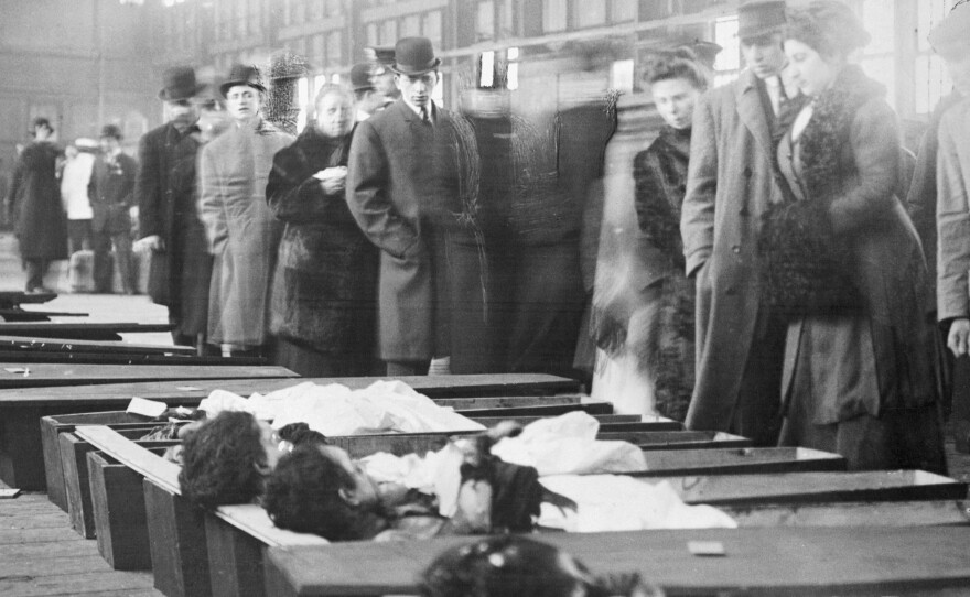 Family members arrive at the New York City morgue to identify the bodies of victims of the Triangle Shirtwaist Company Fire that killed 146 factory workers, mainly young immigrant women.