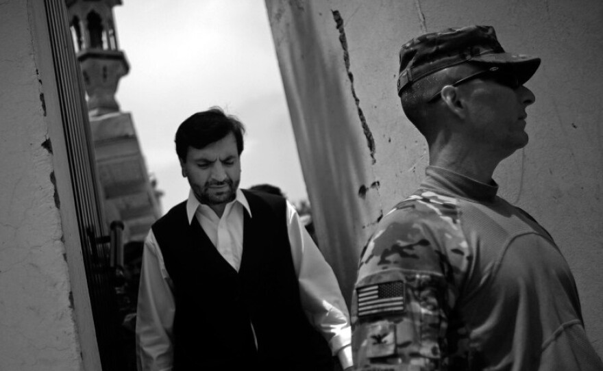 Governor Abdul Jabbar Naeemi walks through his compound with Col. Chris Toner after after a lunch and meetings in the governor's compound in the provincial capital.