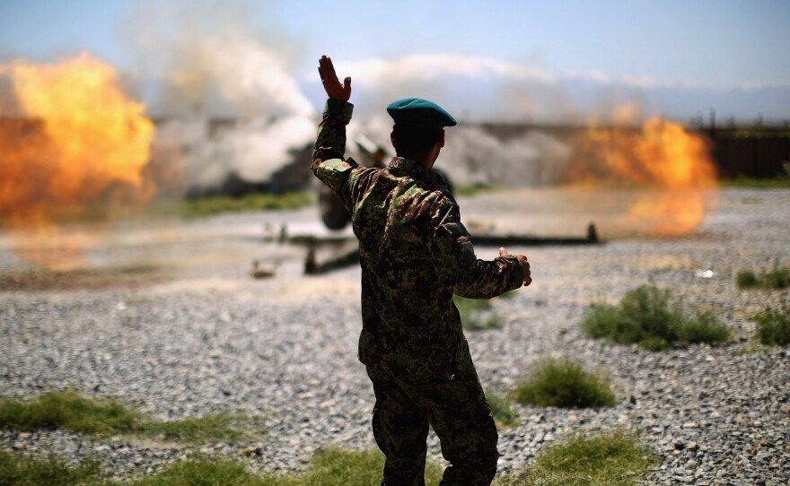 An artillery gun fires a round at Taliban fighters in the hills of Nangahar Province.