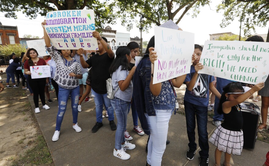 Children of mainly Latino immigrant parents hold signs in support of them and other individuals swept up during an immigration raid at a food processing plant in Mississippi.