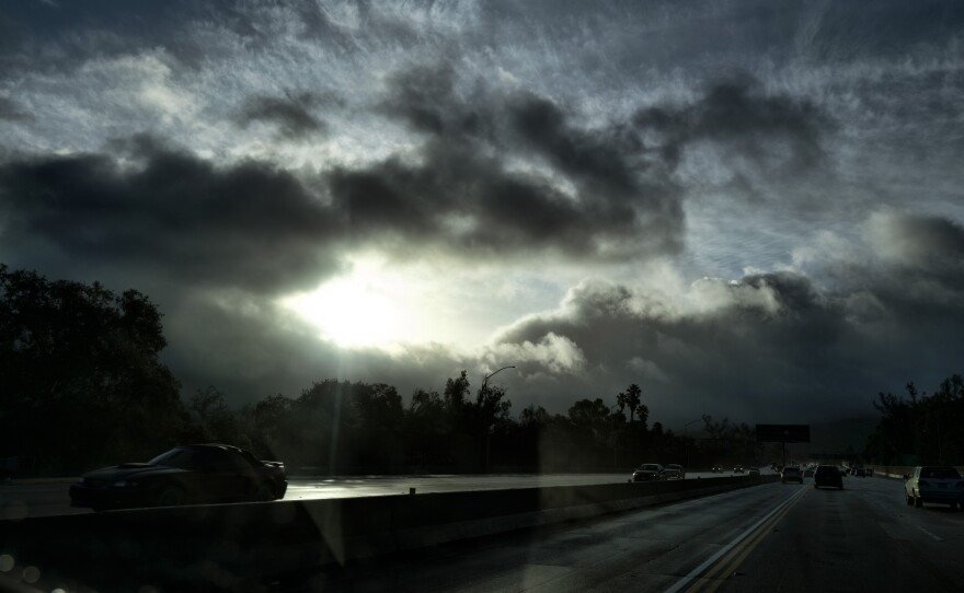 A glimmer of sunshine is seen as fast moving storm clouds pass over the Hollywood Freeway early Monday, Jan. 16, 2023, in Los Angeles.
