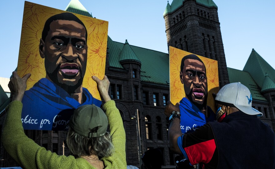 People gather during a demonstration outside the Hennepin County Government Center in Minneapolis on Monday as opening statements were given in the trial of former Minneapolis police officer Derek Chauvin for the killing of George Floyd.