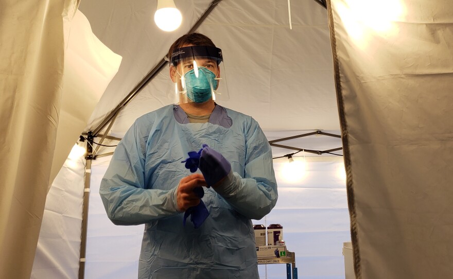 Nurse Jeff Gates prepares to assess another patient in UW Medicine's drive-through coronavirus testing clinic in Seattle.