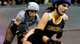 Skaters from the Tough Cookies (in blue) and the Varsity Brawlers (in purple) are seen during an L.A. Derby Dolls match last month. The teams' athletes include Agnus Die and Vik Timizer of the Varsity Brawlers and Aggro Vader and Iron Maiven of the Tough Cookies.