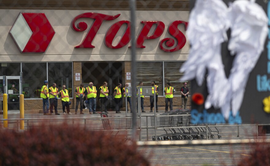 Tops Markets announced Monday that its Buffalo, N.Y. location will reopen on July 15 following the deadly mass shooting in May. Here, investigators stand outside during a moment of silence for the victims of the Buffalo supermarket shooting outside the Tops Friendly Market on Saturday, May 21, 2022.