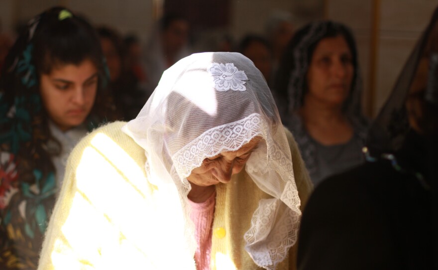 An Assyrian Christian woman prays at a church service in Tell Tamer, Syria. The service is to remember members of the community killed after about 300 people were taken captive by ISIS in March 2015.