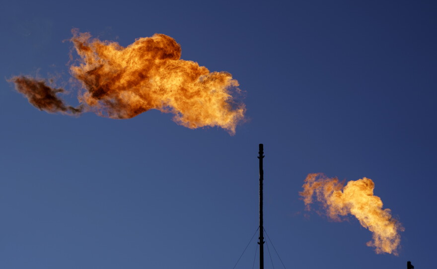 Flares burn off methane and other hydrocarbons at an oil and gas facility in Lenorah, Texas, Oct. 15, 2021.