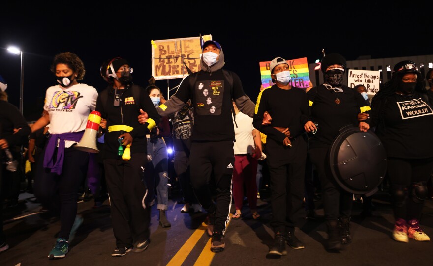 Demonstrators lock arms as they march for Daniel Prude on Friday in Rochester, N.Y. Prude died after being arrested on March 23 by Rochester police officers, who had placed a "spit hood" over his head and pinned him to the ground while restraining him.