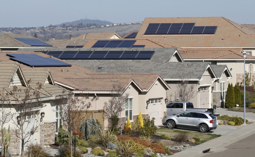 This file photo taken Wednesday, Feb. 12, 2020, shows solar panels on rooftops of a housing development in Folsom, Calif.