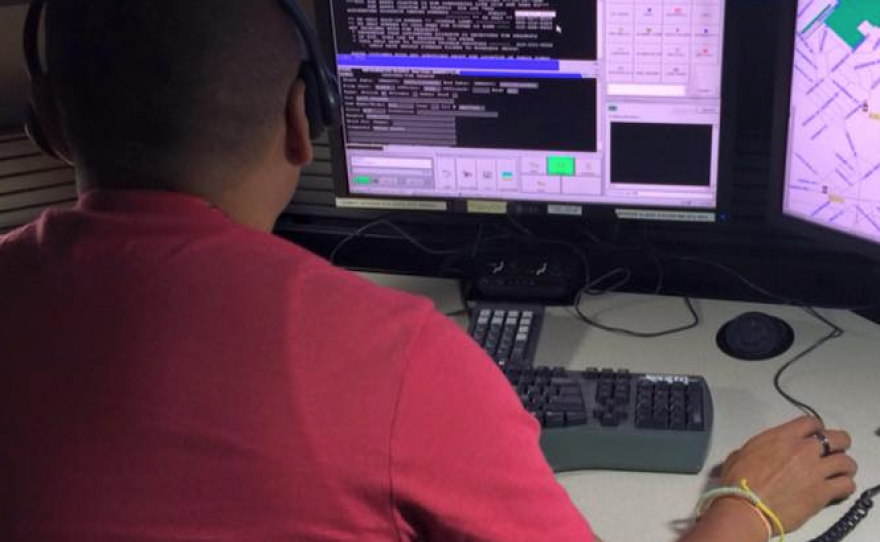 A police dispatcher sits at his desk in this undated photo.