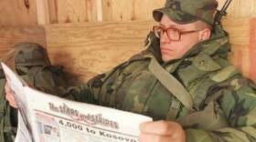 US soldier Sgt. John Hubbuch of Versailles, Ky., one of the members of NATO led-peacekeeping forces in Bosnia reads Stars and Stripes newspaper on Sunday Feb. 14, 1999.