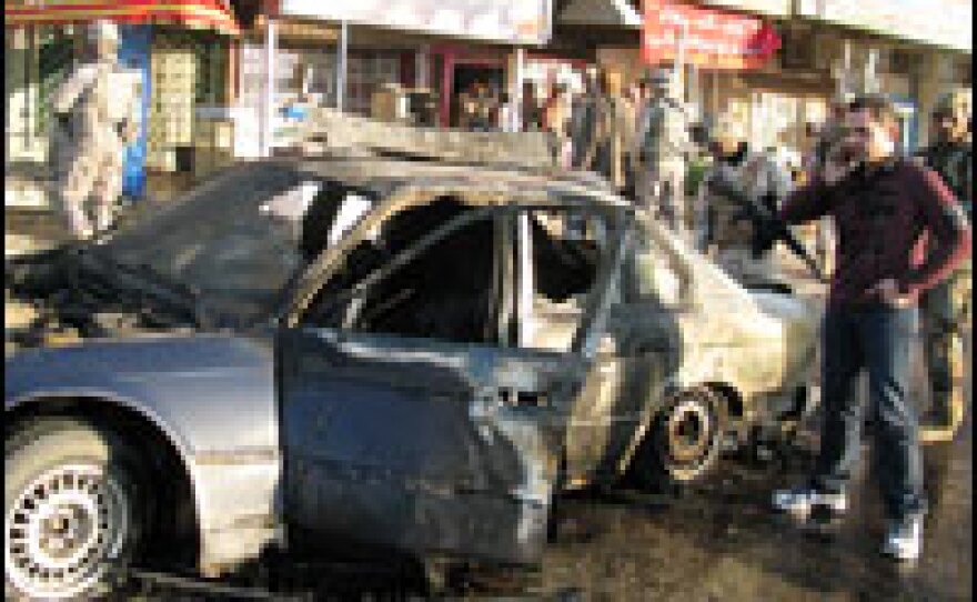 Hamdani stands beside the wreckage of NPR's armored BMW when it was blown up in 2008.
