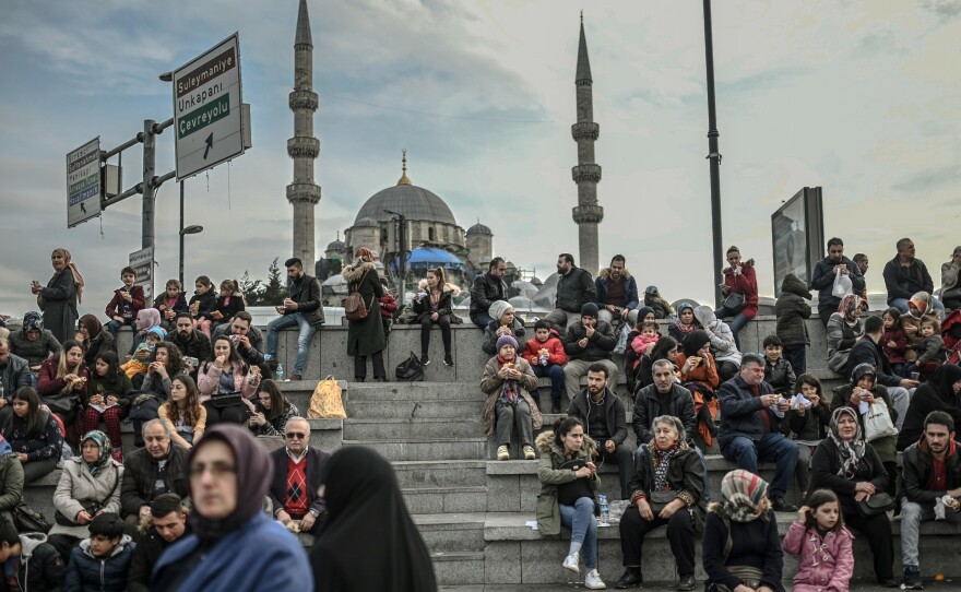 People enjoy an afternoon at Eminonu Square in Istanbul in January. A recent survey of personal beliefs and lifestyles in majority-Muslim Turkey has found a smaller portion of people describing themselves as religious.