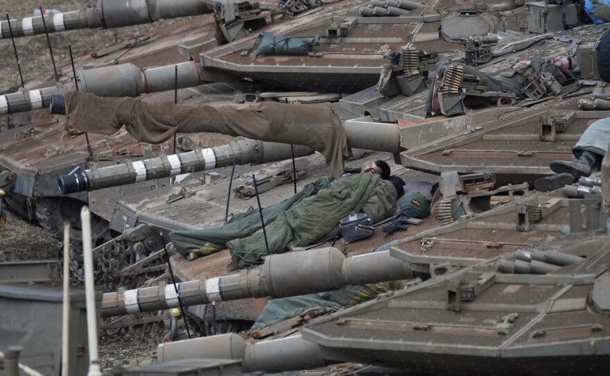 Israeli soldiers sleep on tanks in a staging area in northern Israel near the Israel-Lebanon border, Tuesday, Oct. 1, 2024.